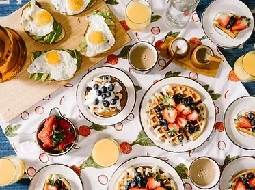 An overhead shot of a table covered with plates of breakfast foods.
