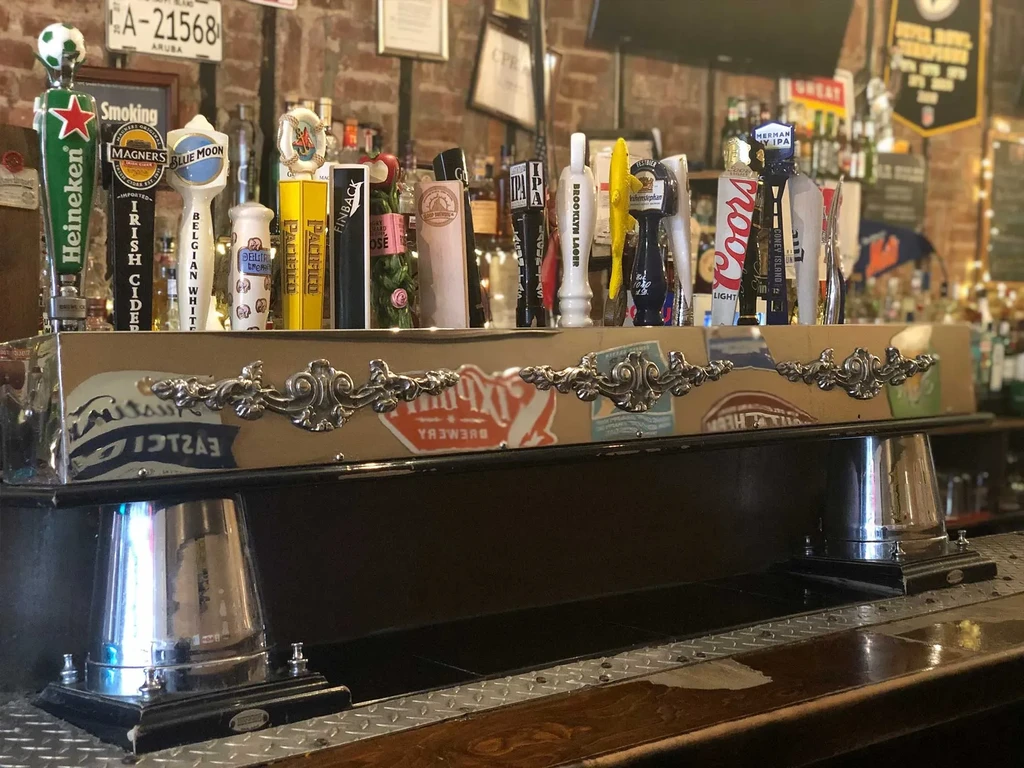 A beer tap system at a bar with various beer brands.