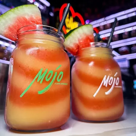 Two "Mojo" branded watermelon swirl drinks in mason jars with straws.
