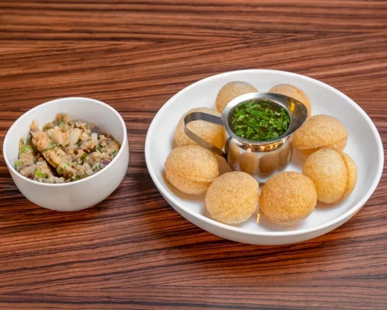 Pani puri served with green water and potato filling.