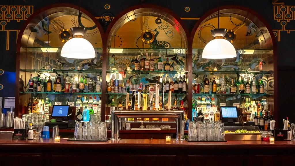 A well-stocked bar with various bottles, glasses, and beer taps.