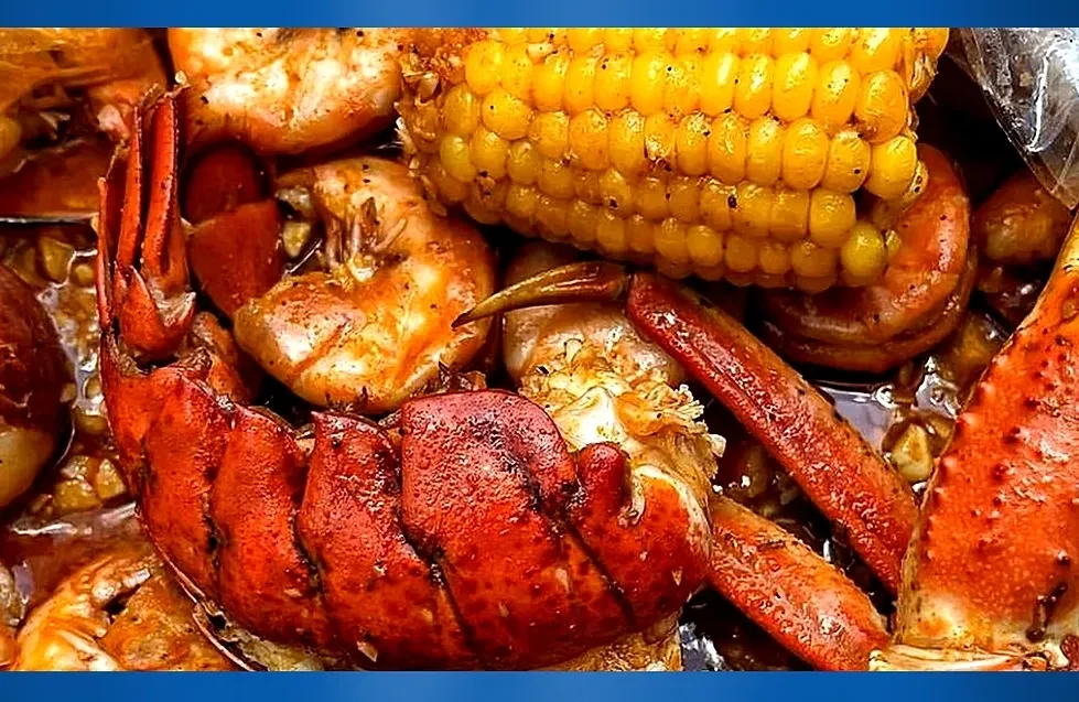 A seafood boil with lobster, shrimp, crab legs, and corn.