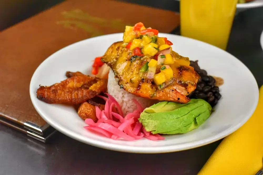 Grilled fish with mango salsa, rice, black beans, avocado, and plantains.