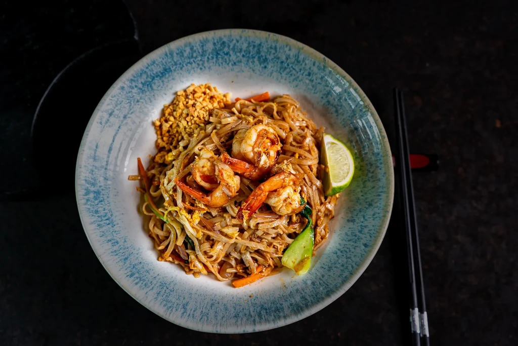 Overhead shot of Pad Thai with shrimp, peanuts, and lime wedge.