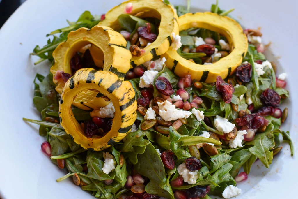 Arugula salad with acorn squash rings, feta, dried cranberries, and pomegranate.