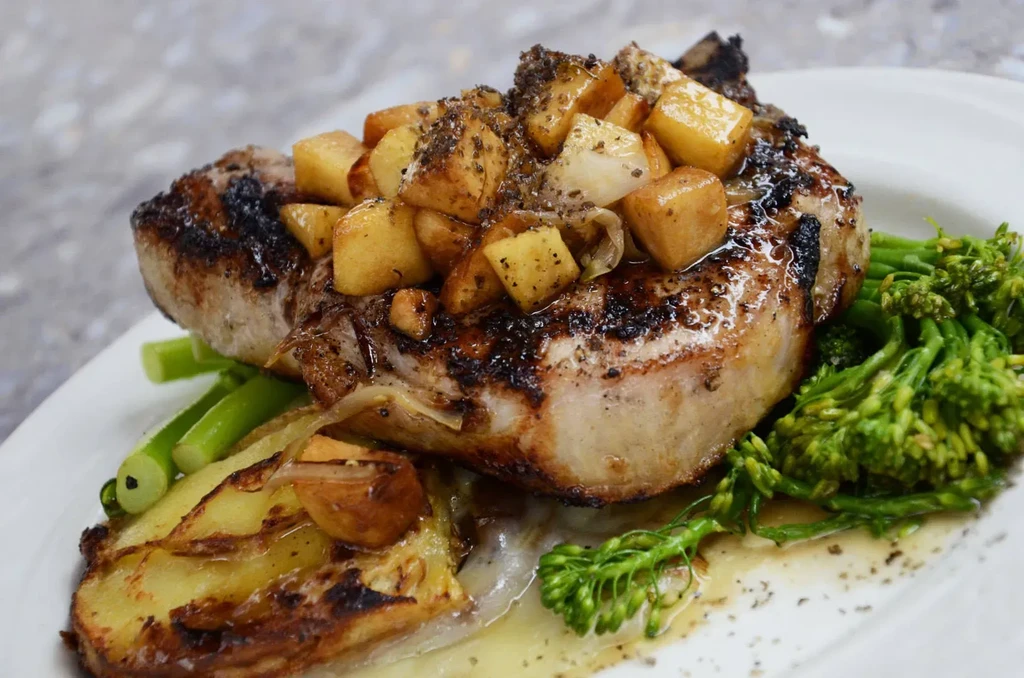 Grilled pork chop with diced potatoes, broccoli, and green beans.