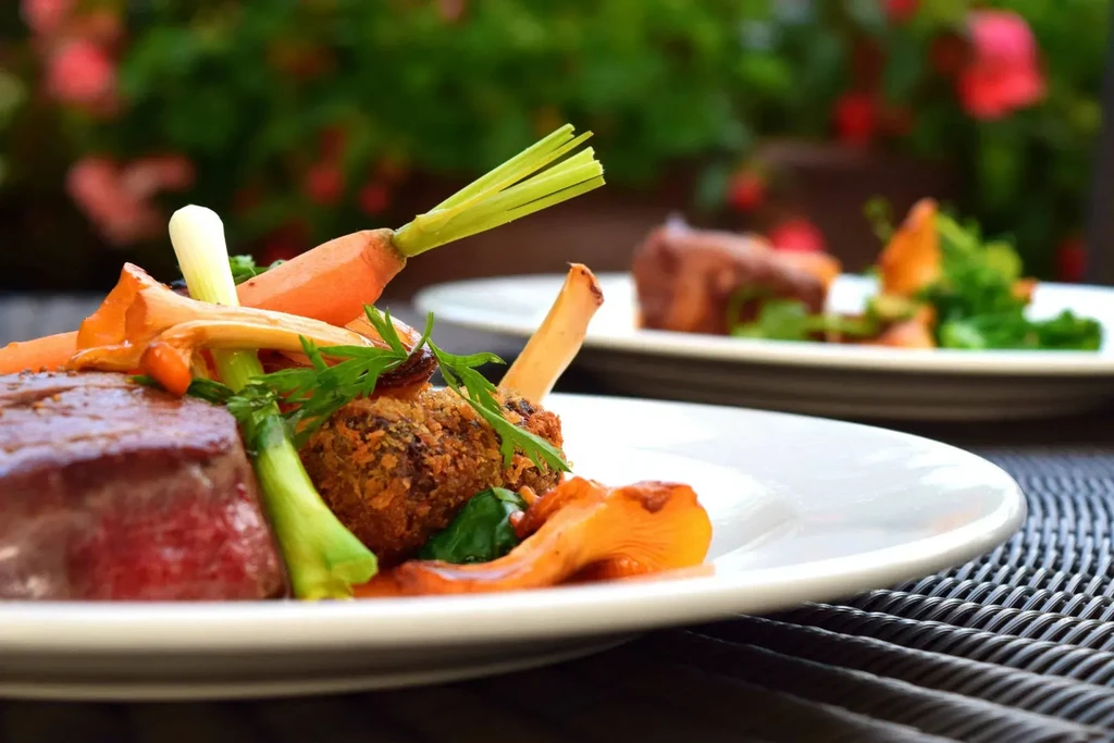 Close-up of a meat and vegetable dish on a white plate.