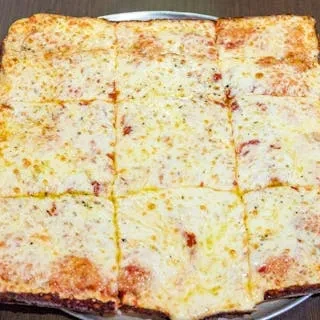 A rectangular pizza with evenly melted cheese cut into 12 squares.