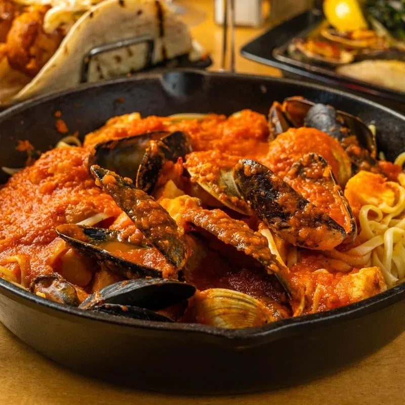 Seafood pasta with mussels and clams in a red sauce.