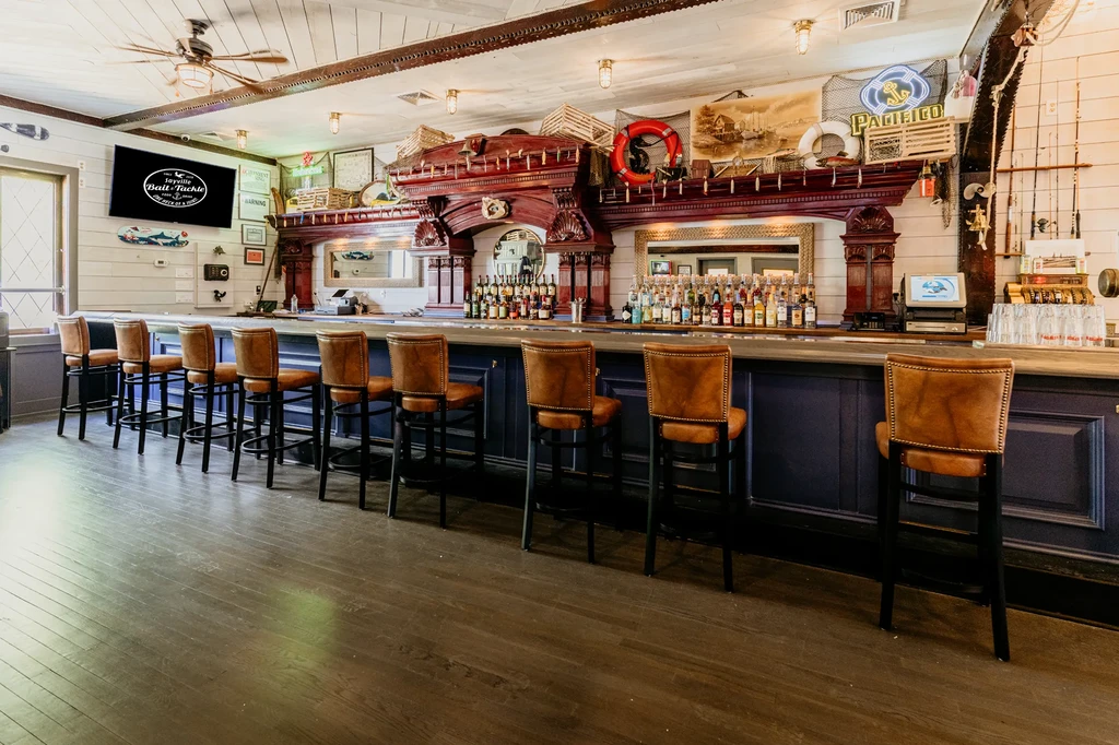 A long bar with many stools and a coastal-themed decor.