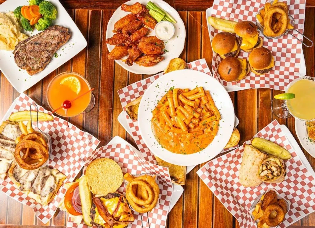 Overhead view of various dishes and drinks on a wooden table.