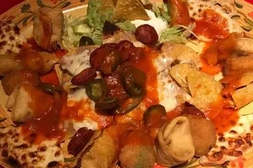 A large platter of Mexican appetizers with various fried items and sauces.