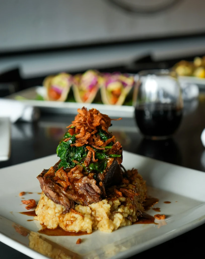 Braised short rib on risotto with spinach and crispy onions.
