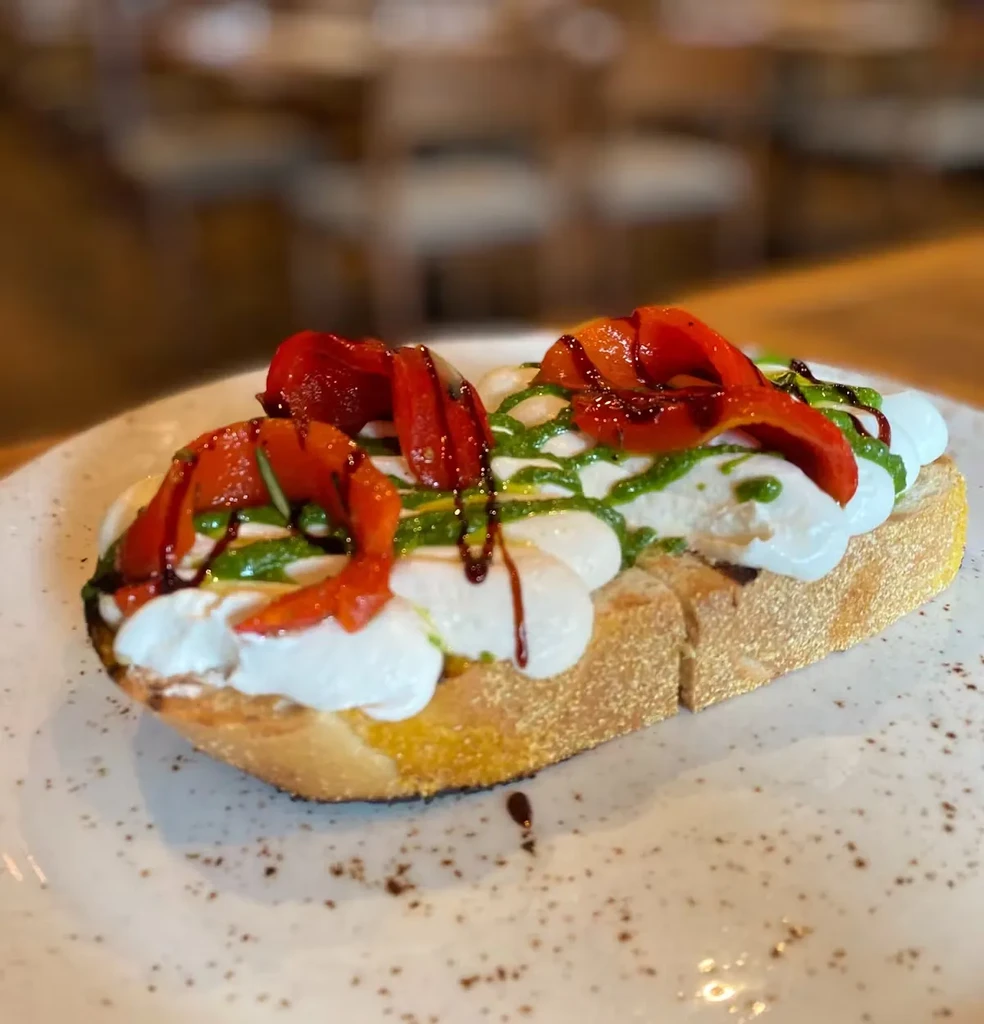 Bruschetta with mozzarella, roasted red peppers, pesto, and balsamic glaze.
