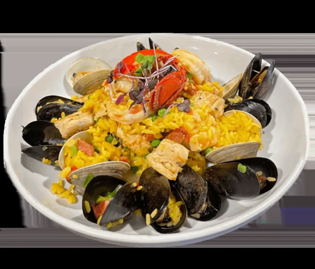 A white bowl filled with paella, lobster, mussels, and clams.
