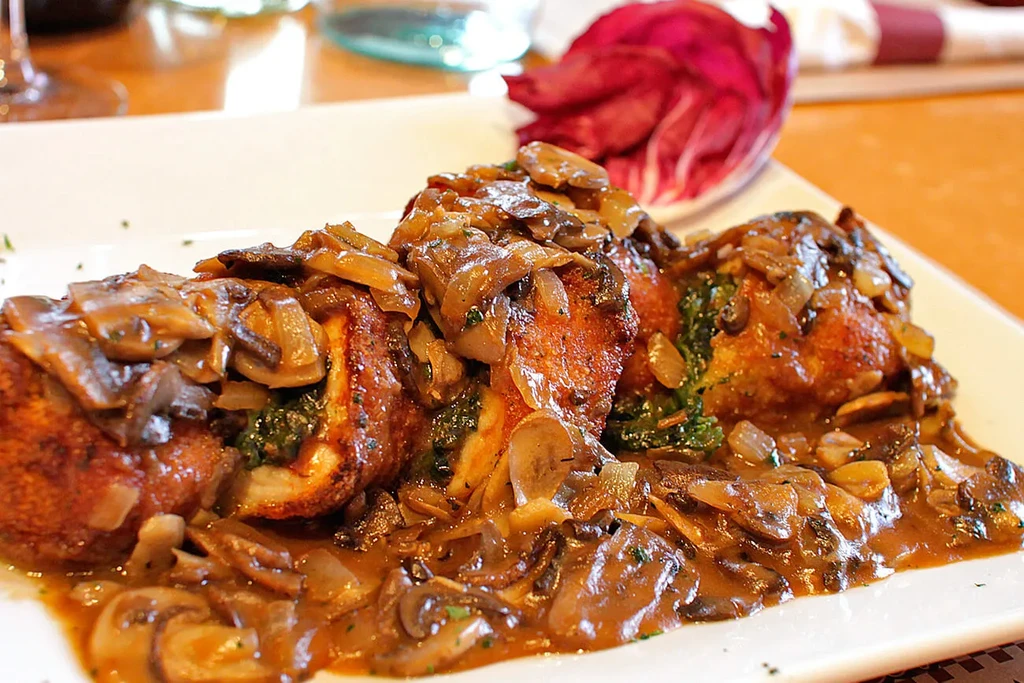 Fried chicken breast with mushroom sauce and spinach filling.