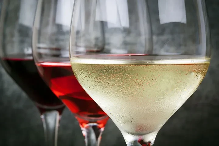 Three overlapping wine glasses: chilled white, rosé, and dark red.