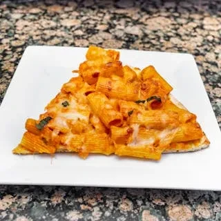 A triangular slice of pizza topped with baked ziti pasta.