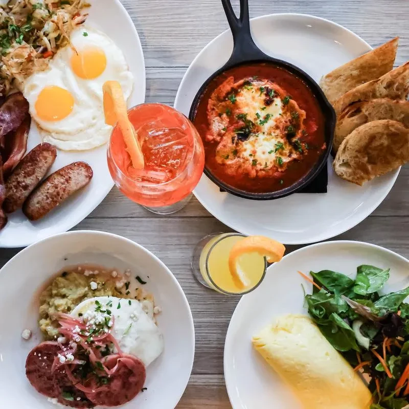 Overhead view of a table spread with four different breakfast plates.