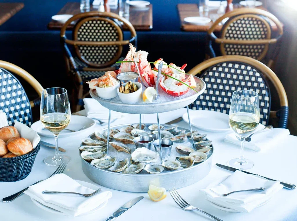 A seafood tower with oysters and lobster tails at a restaurant.