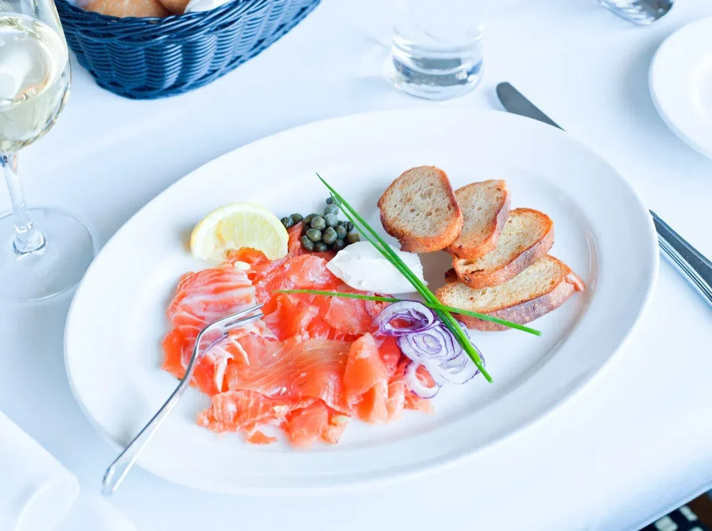 Smoked salmon with capers, lemon, cream cheese, onions, chives, and toast.