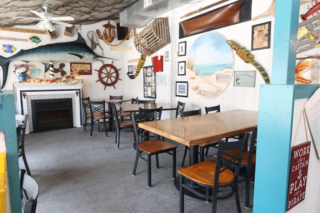 A nautical-themed restaurant with tables, chairs, and maritime decor.