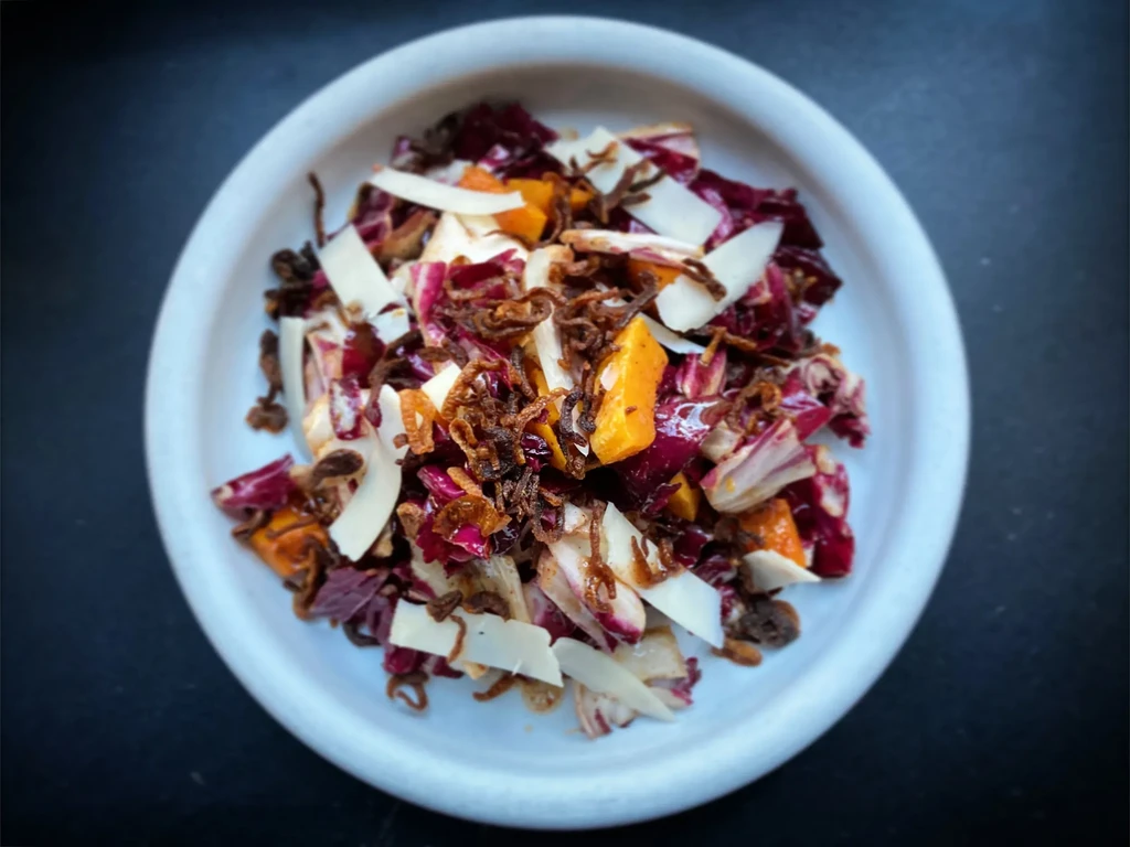 Colorful salad with radicchio, roasted squash, crispy onions, and Parmesan.