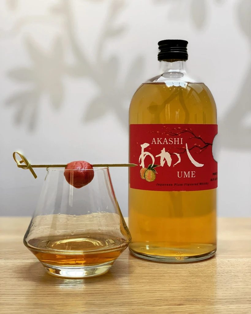 Akashi Ume plum whisky bottle, glass with plum garnish.