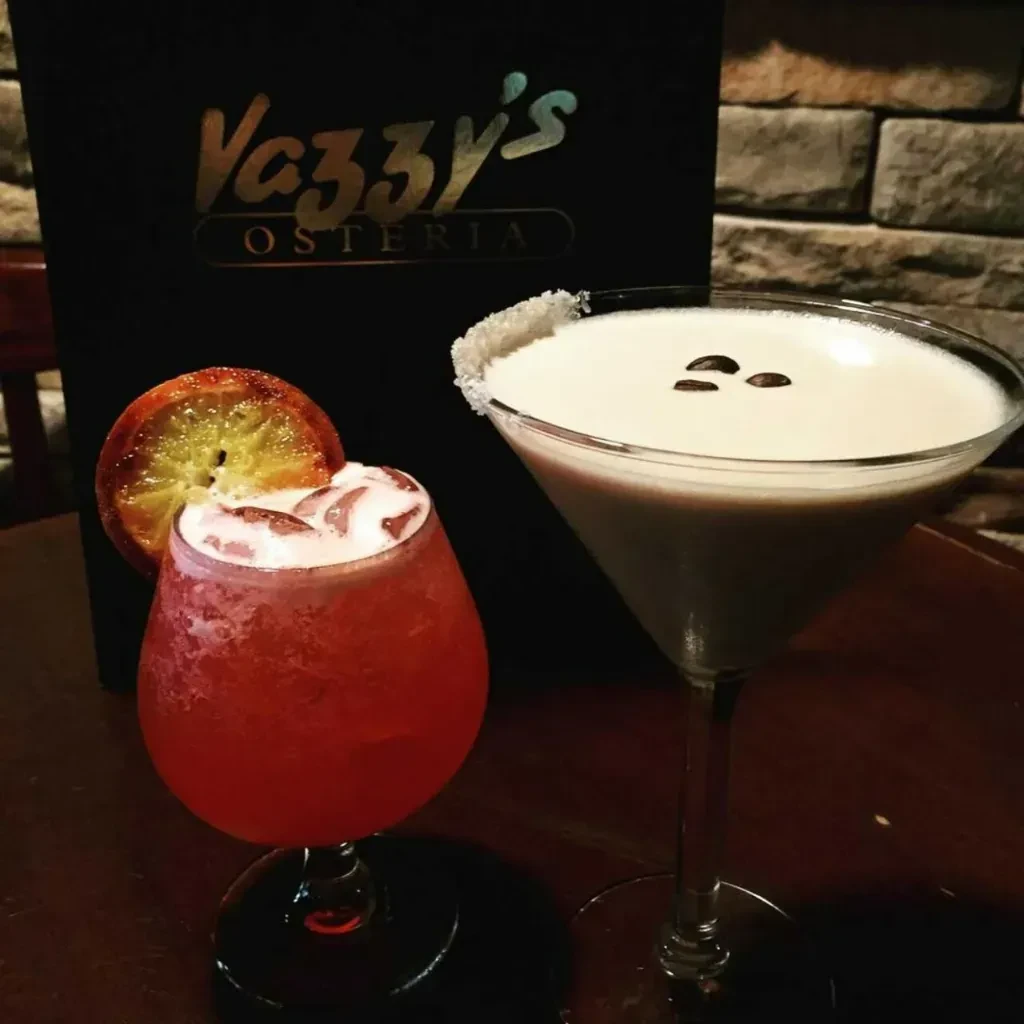 Red cocktail with orange, beige cocktail with coffee beans at Vazzy's.