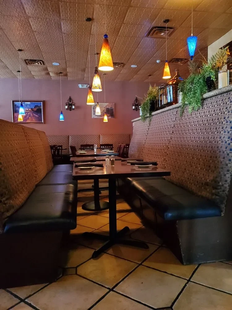 Restaurant interior with booth seating, warm lighting, and mosaic partition.