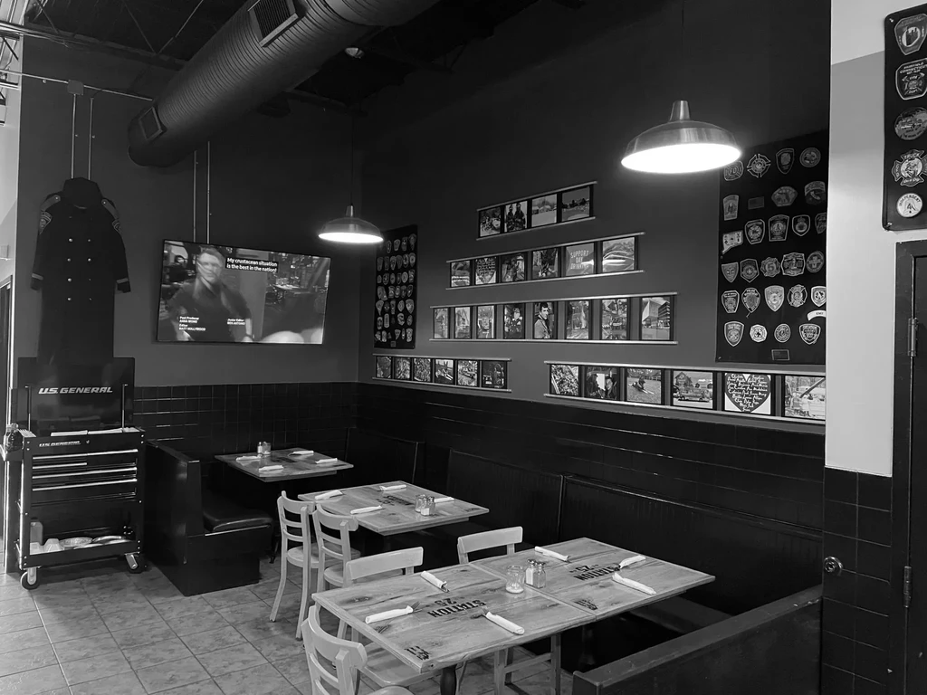 Black and white restaurant interior with industrial and fire service decor.