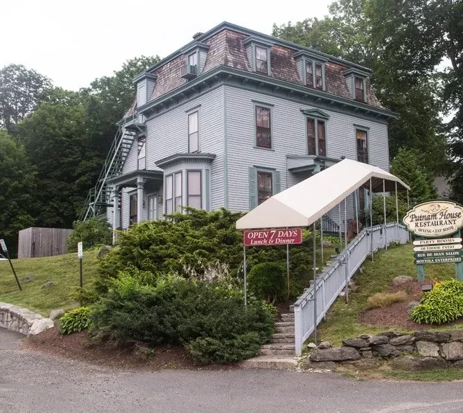 Historic Putnam House Restaurant building with mansard roof, fire escape, and signs.