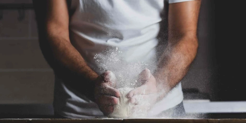 Hands clap together, creating an explosion of white powder.