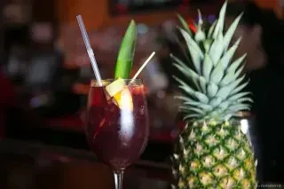 A glass of sangria with a pineapple.
