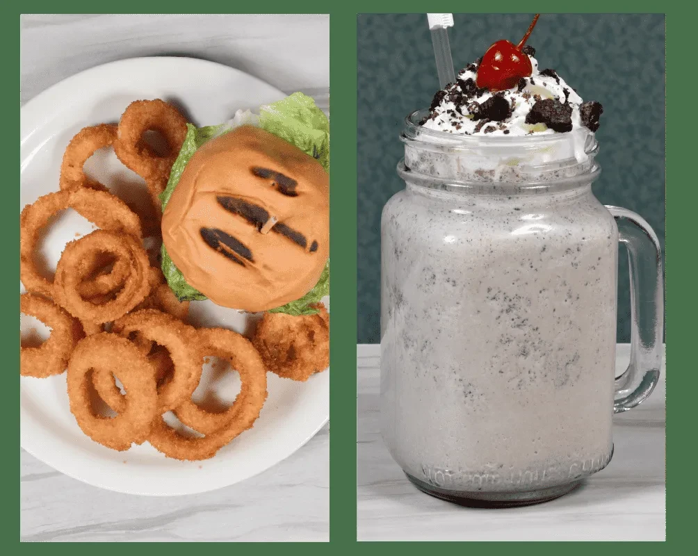 A burger with onion rings and a milkshake with whipped cream and cherry.