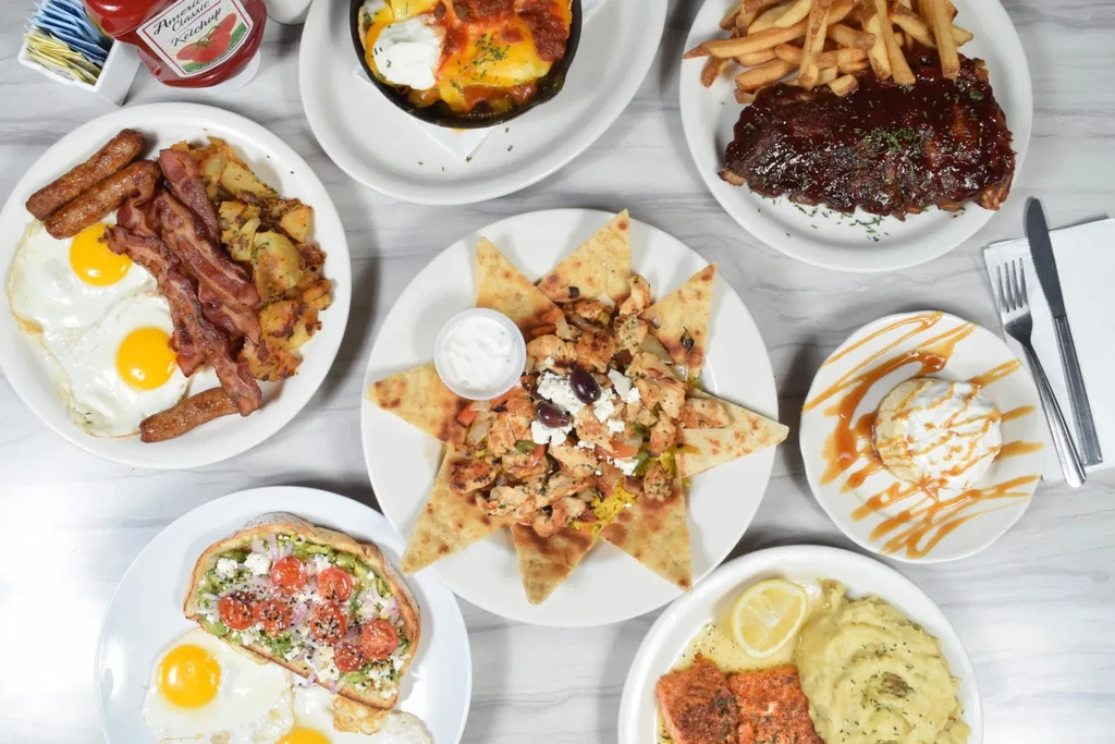 An overhead shot of several plates of food arranged on a table.
