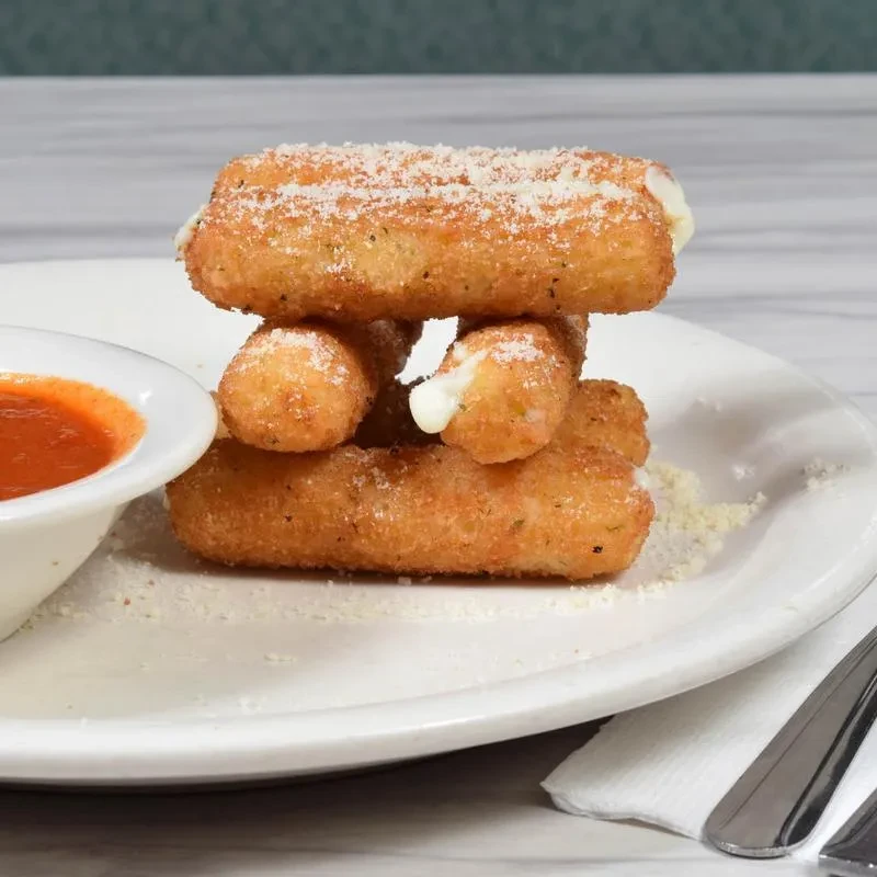 A plate of mozzarella sticks, sprinkled with parmesan cheese and a side of marinara sauce.