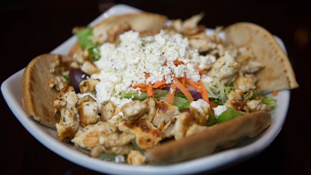 A Greek chicken pita salad with feta cheese.