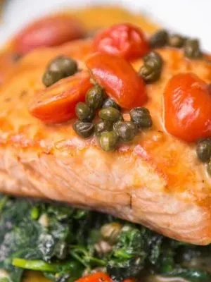 Salmon fillet with capers, tomatoes, and spinach.