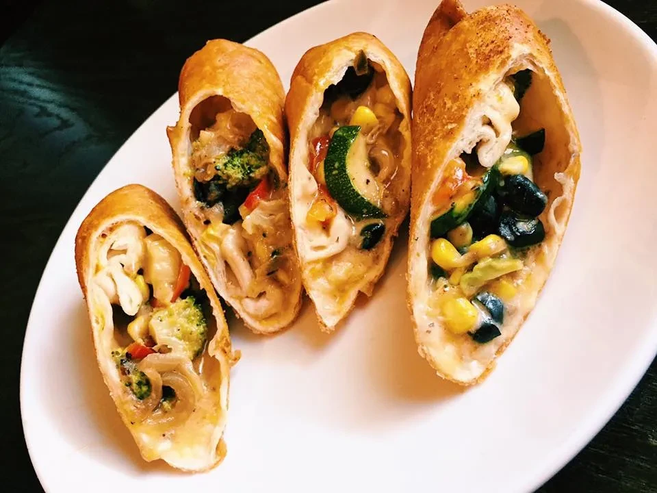 Crispy golden pastries filled with creamy mixed vegetables on a plate.