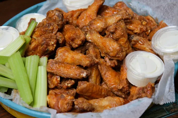 Piled high Buffalo wings, celery sticks, and creamy dipping sauces.