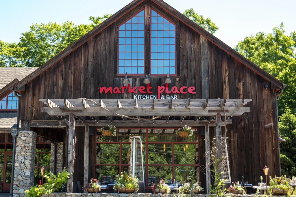 Rustic "market place KITCHEN & BAR" restaurant, patio, and flowering pergola.