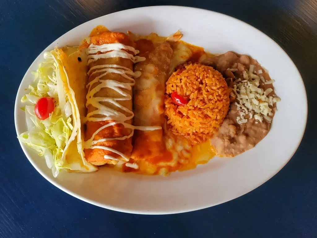 Plate of Mexican food: red enchiladas, rice, beans, and salad.