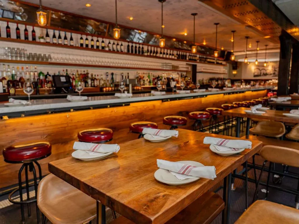 An empty restaurant bar and dining area with warm lighting.