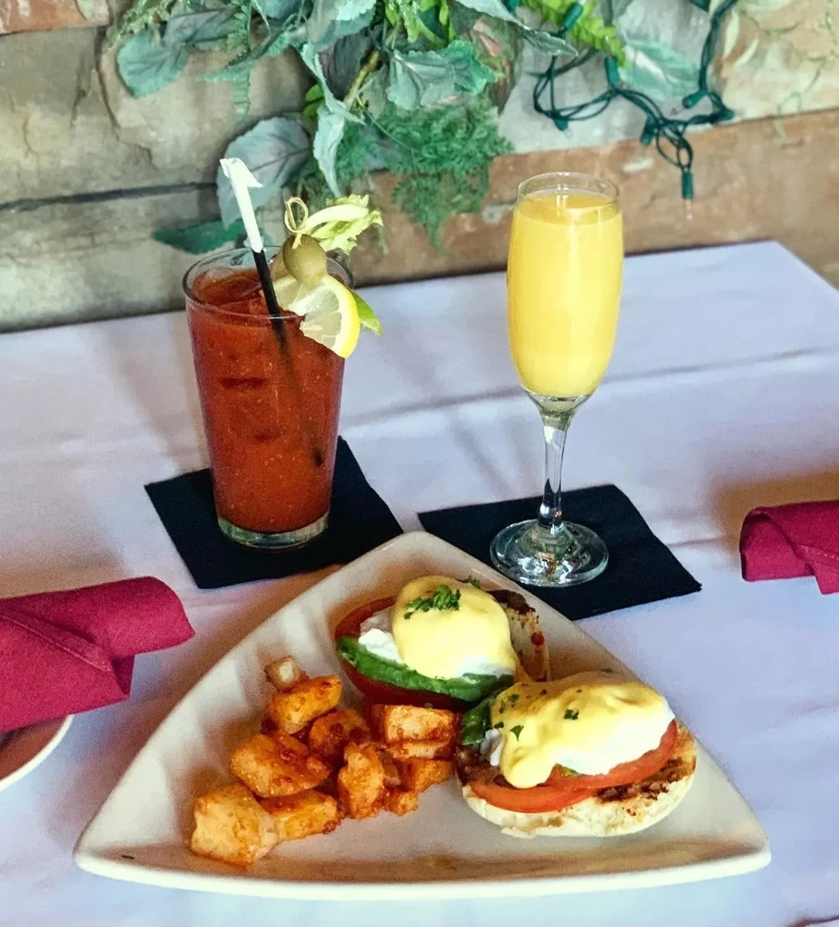Two Eggs Benedict with home fries, a Bloody Mary, and Mimosa.