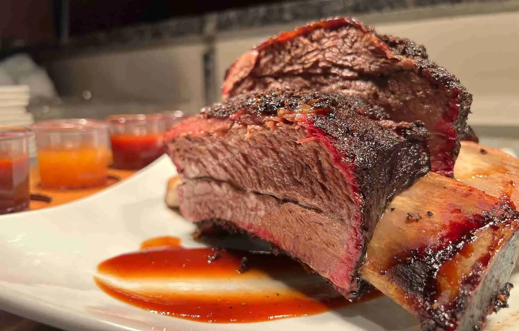 Two cuts of barbecued meat with crusty bark and pink smoke ring.