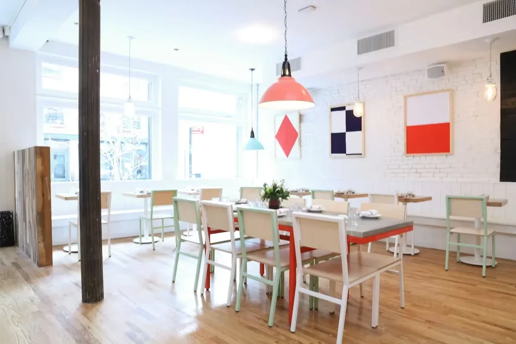 Clean, modern restaurant interior with white brick walls and colorful chairs.