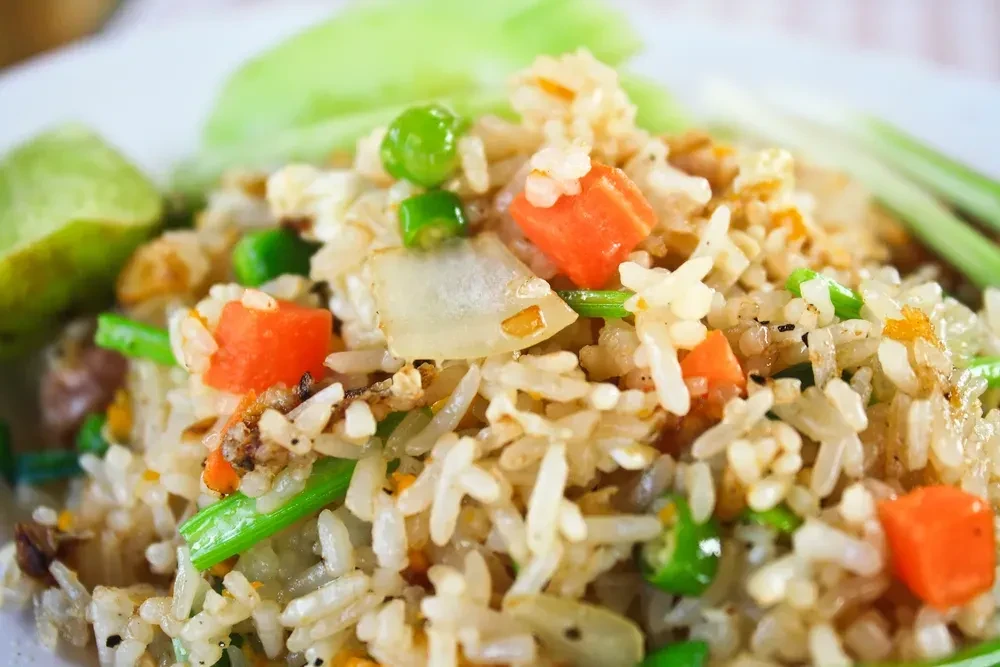 Close-up of fried rice with carrots, peas, and green beans.