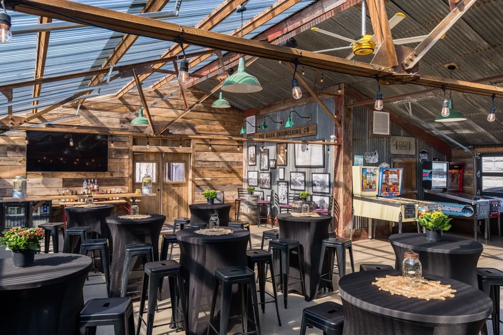 A rustic bar and event space with wood, metal, and exposed rafters.