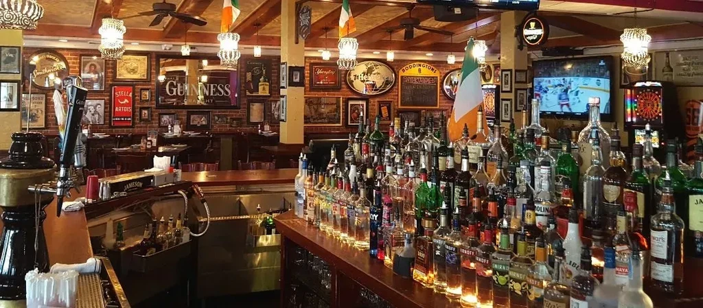 An Irish pub with a long bar stocked with many liquor bottles.